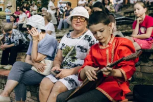 Jeune garcon en chemise rouge traditionnelle jouant de la balalaika lors d une fete populaire en Russie
