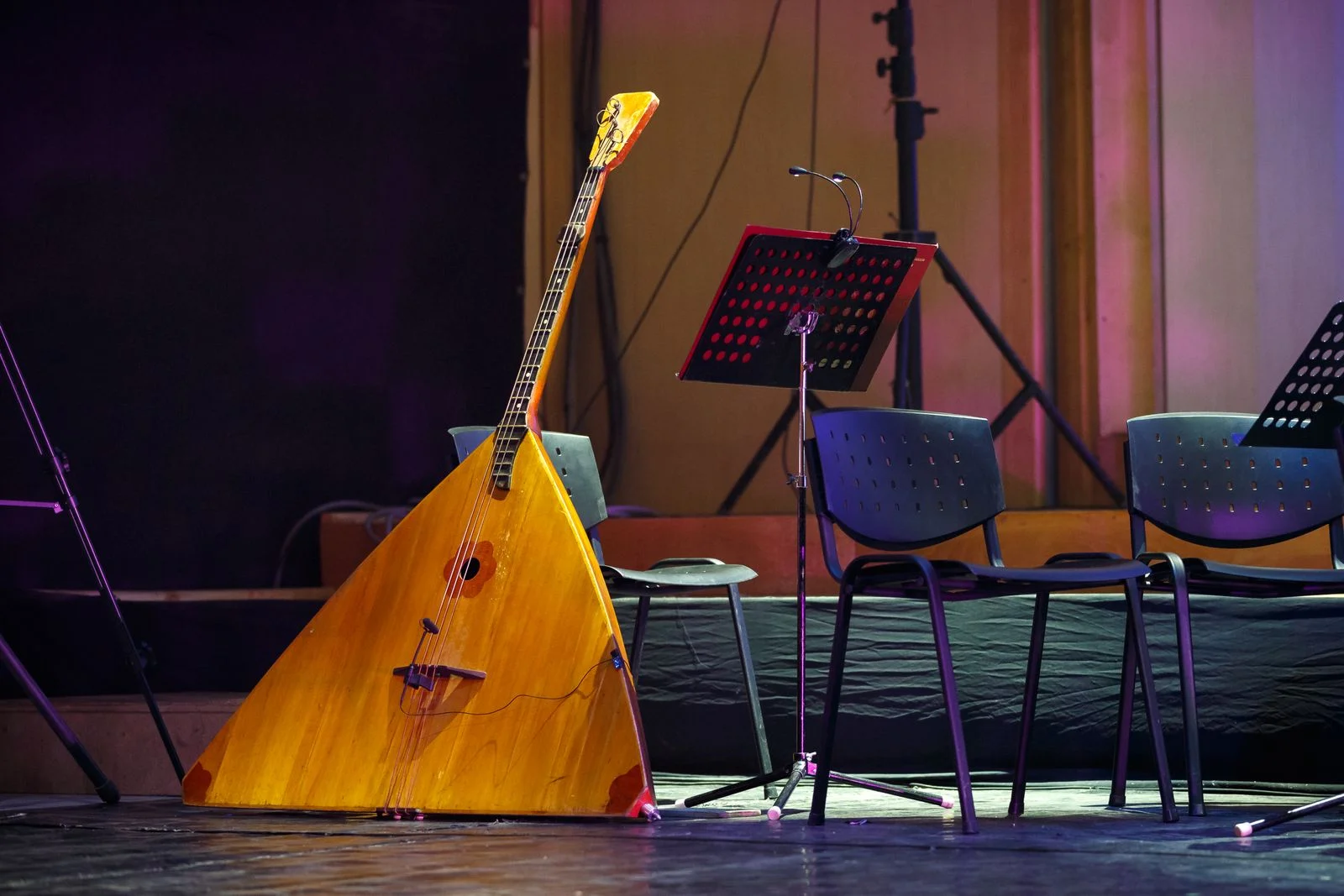 Balalaika posee sur une scene, corps en bois triangulaire, manche long et trois cordes, caisse de resonance ronde percee dans la table