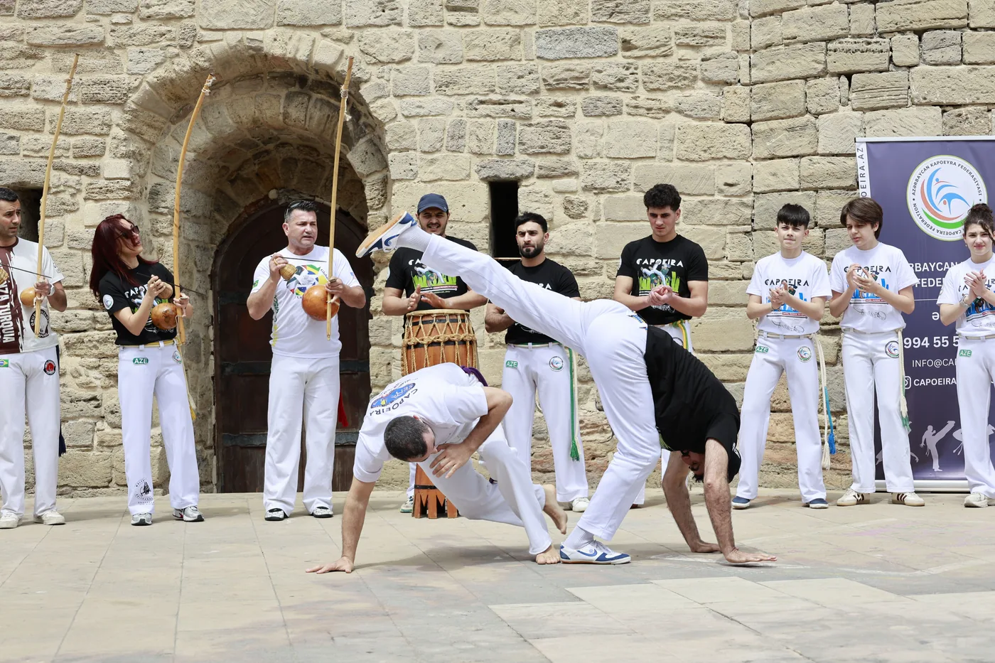 Joueurs de berimbau et d'atabaque autour d'une roda de capoeira en plein air
