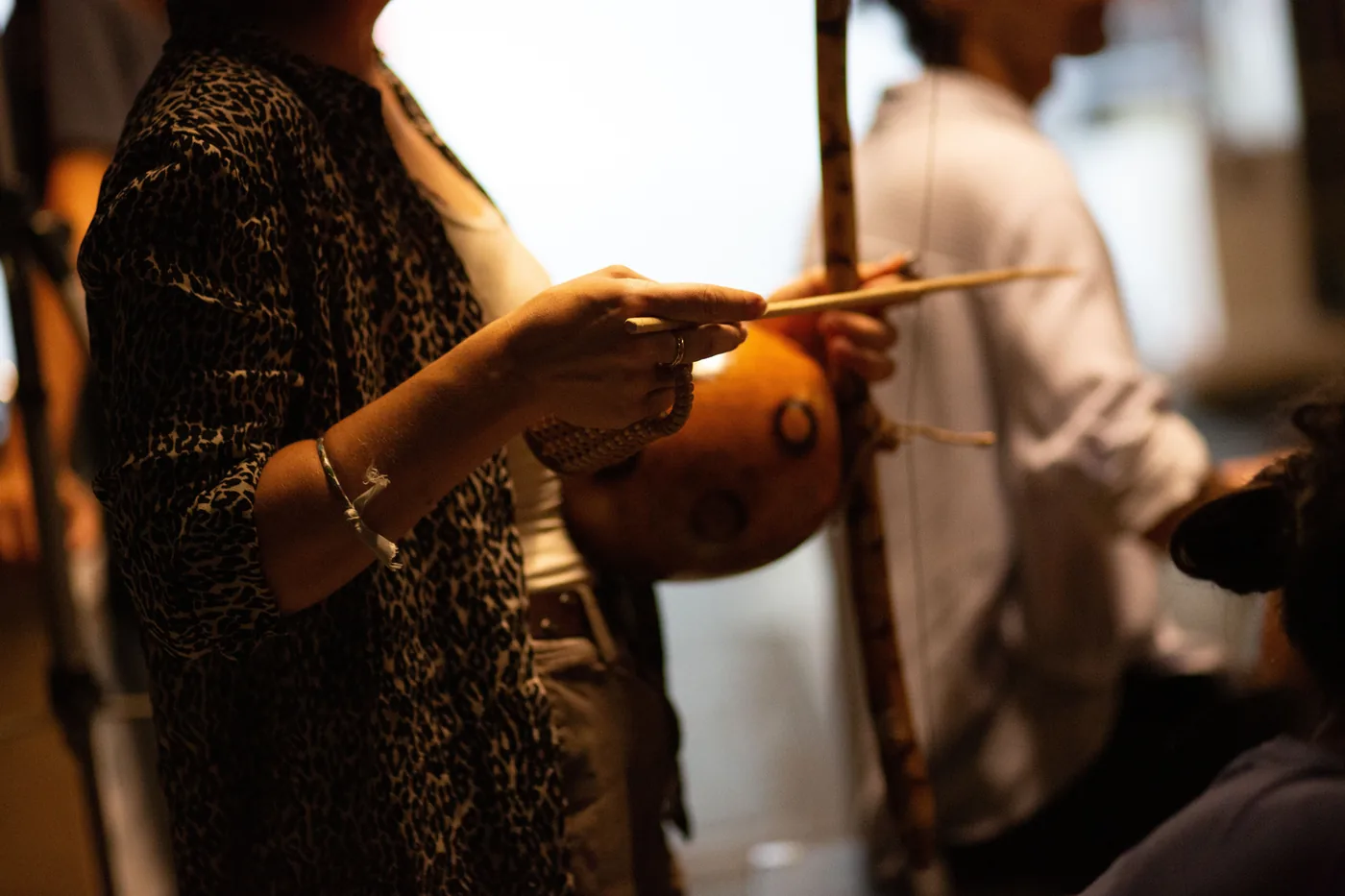 Gros plan sur des mains tenant la verga et la cabaça d'un berimbau avec la baqueta