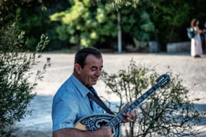 Musicien de rue jouant du bouzouki en Grèce, assis en extérieur