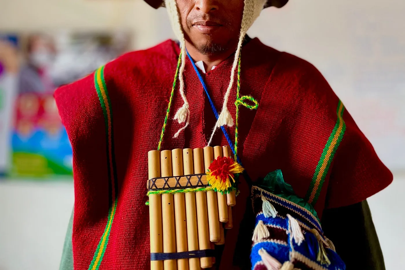 Zampoña andine aux tuyaux de bambou de longueurs étagées, liée par une corde tressée, portée en bandoulière