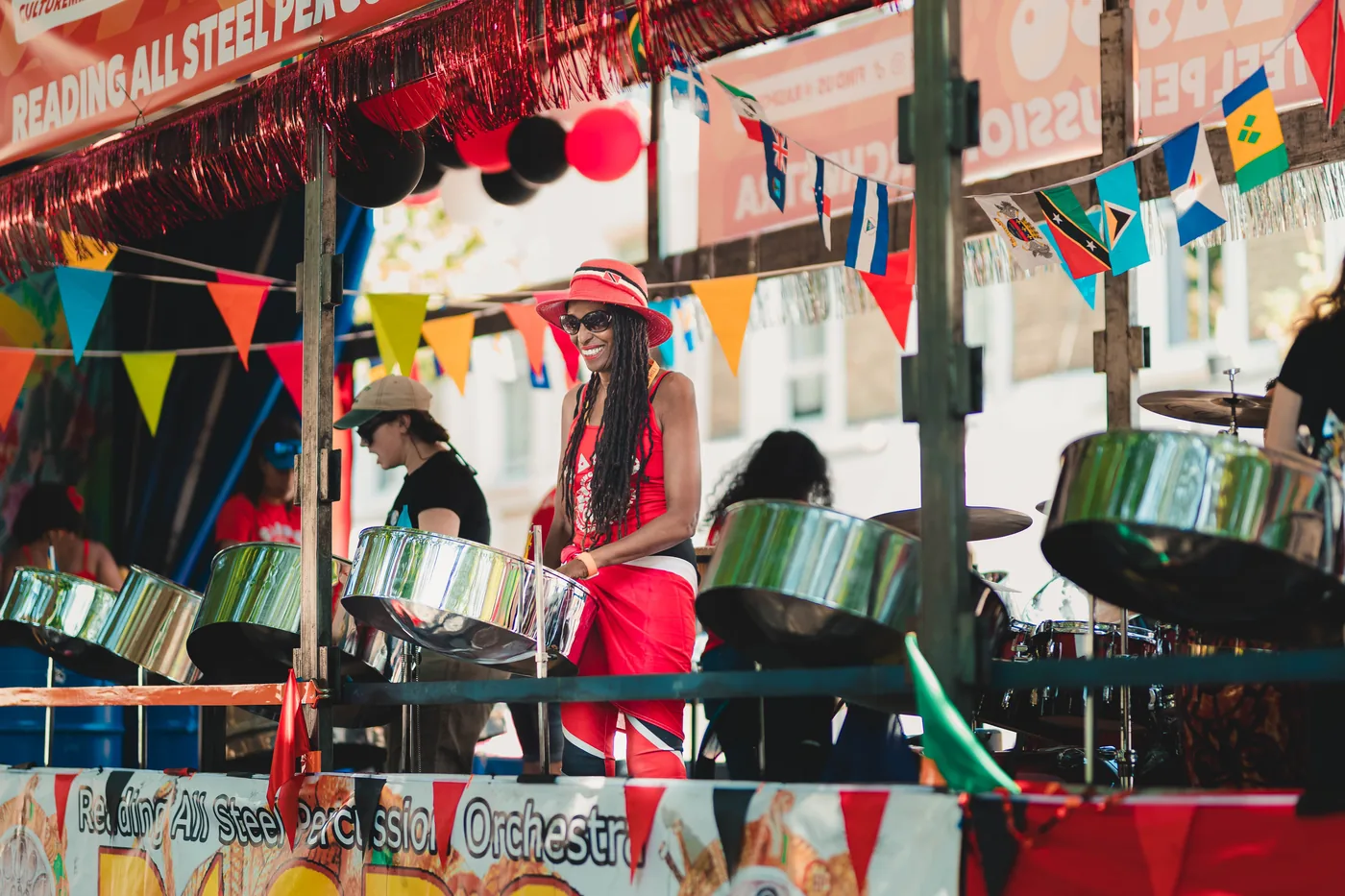 Musiciennes et musiciens d'un steelband jouant sur des steel drums chromés lors d'un défilé de carnaval